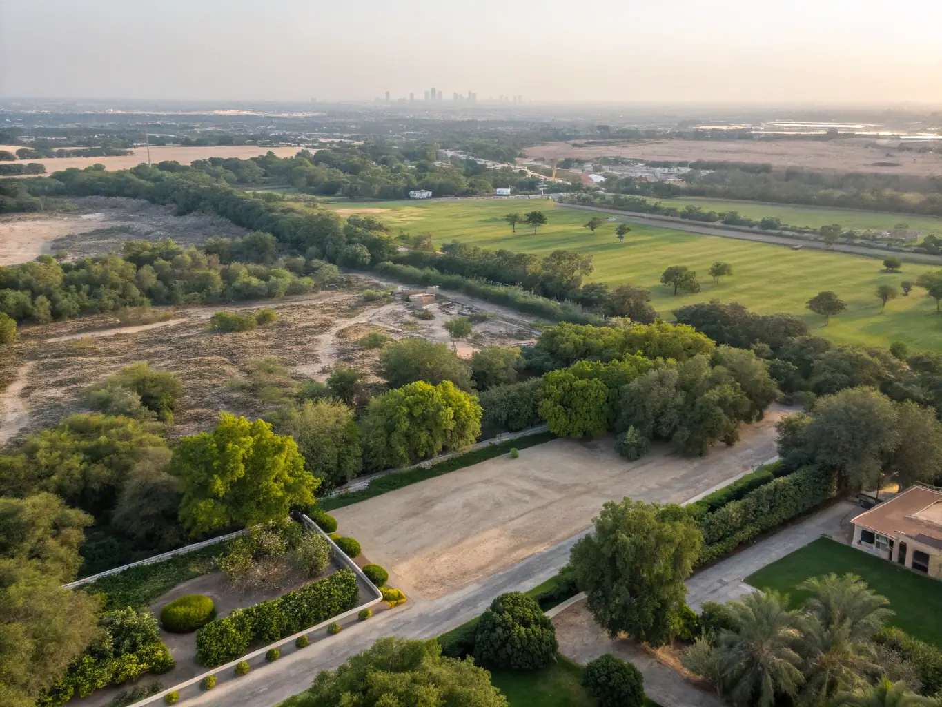 An aerial view of a DAMAC Hills community, highlighting the lush greenery, golf courses, and luxury villas. The image should emphasize the spaciousness and lifestyle amenities of the development.